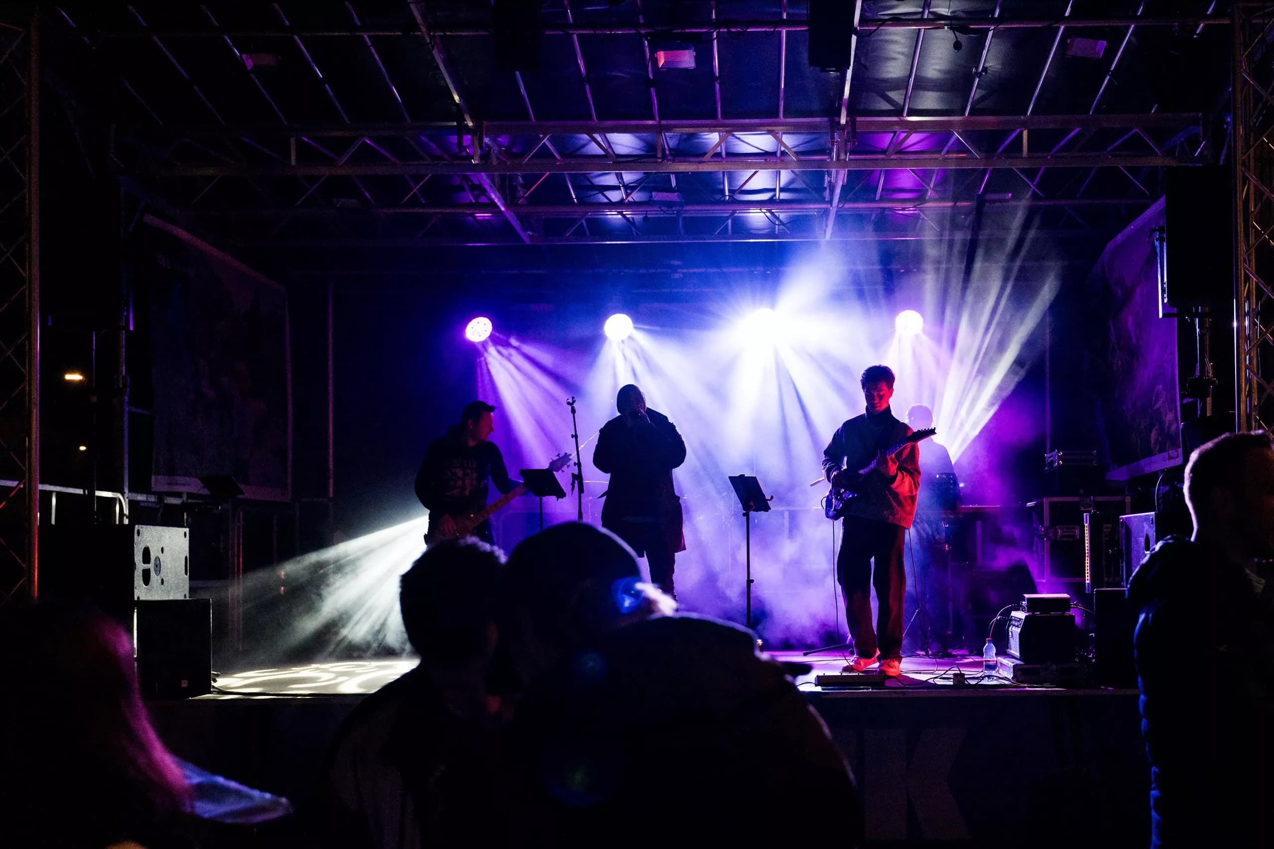 Drei musizierende Figuren sitzen nebeneinander. Einer spielt das Akkordeon, einer die Violine und einer die Flöte.